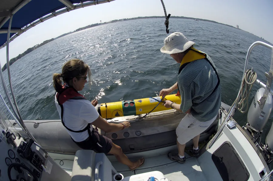 Two researchers preparing to launch a REMUS AUV from a small boat during AUV Fest 2007