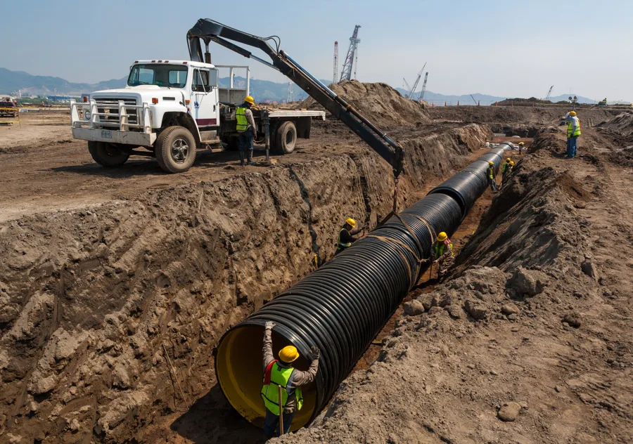 High-density polyethylene (HDPE) pipe being installed in a construction trench